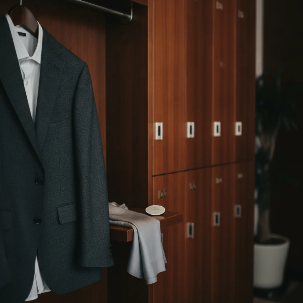 Vestiaire élégant avec casiers en bois illustrant le code de conduite d'un lieu événementiel privé